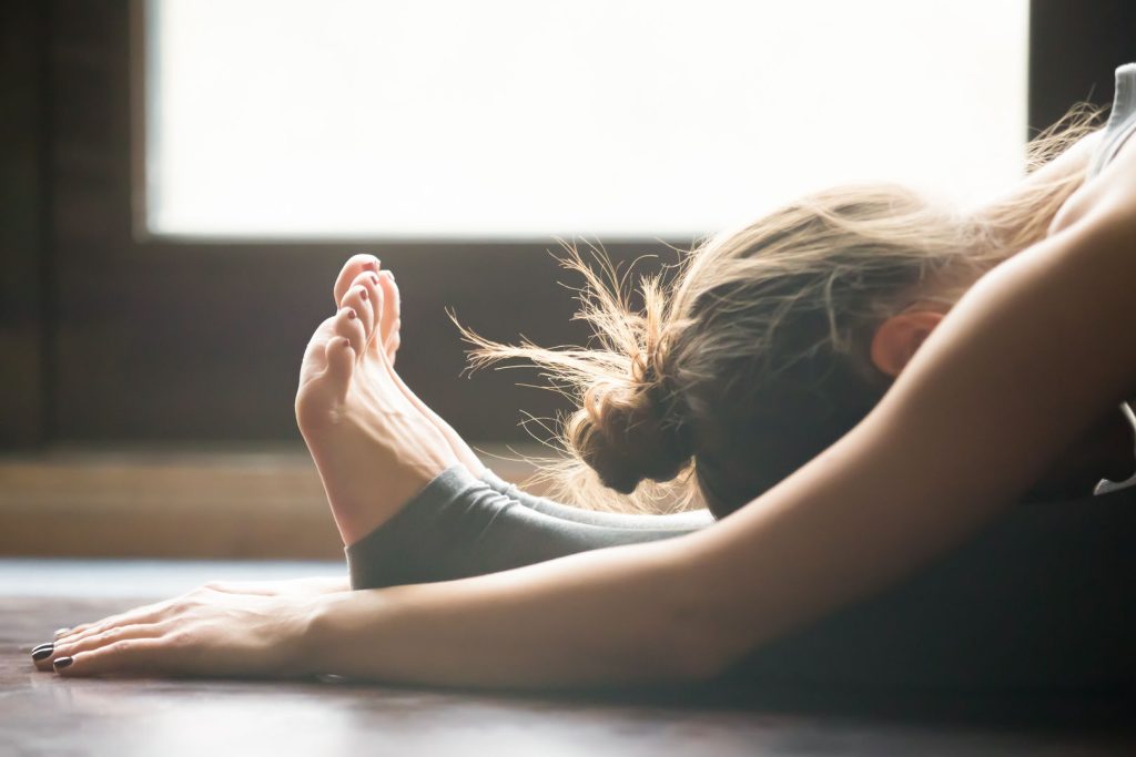 evde yoga hareketleri oturarak öne eğilme pozu